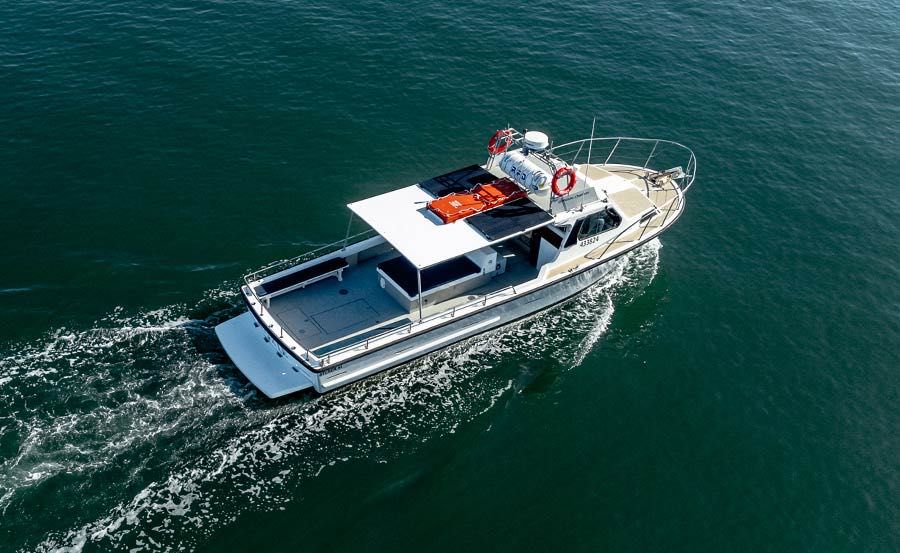 boat features a covered deck area, life rings, and safety equipment on the roof